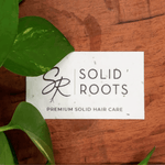 Load image into Gallery viewer, Image of a Solid Roots Gift Card on a wooden background with greenery
