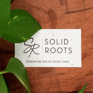 Image of a Solid Roots Gift Card on a wooden background with greenery