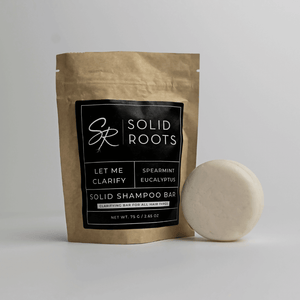 Image of a white shampoo bar next to its packaging